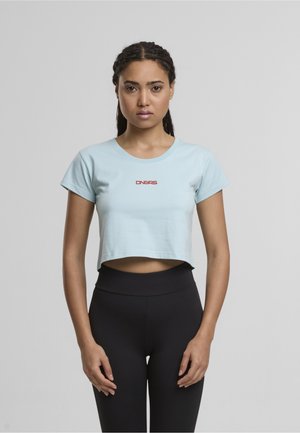 Tricou scurt, de culoare albastră deschisă, dintr-un material moale, cu mâneci scurte, având un logo roșu "DNGRS" pe față. Asortat cu colanți negri.