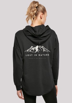Black hooded sweatshirt featuring a mountain graphic and the text "LOST IN NATURE" and "found in the mountains" on the back.