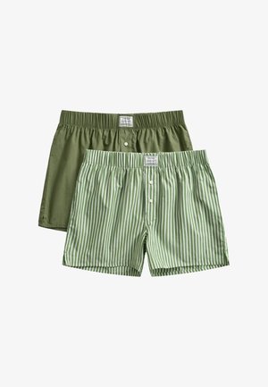 Dos pares de calzoncillos bóxer para hombre, uno en verde oliva sólido y otro verde con rayas verticales blancas, ambos con cierre de botones y cintura elástica.