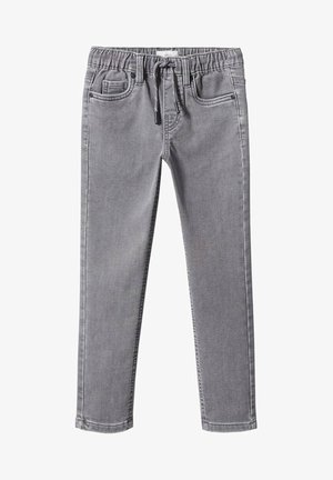 Enfant portant un t-shirt blanc avec un motif de San Francisco, une chemise en jean bleue, un jean gris avec les revers roulés et des baskets beige, debout avec une main sur la hanche.