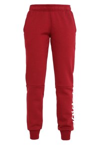 Pantalones de chándal rojos hechos de una mezcla de algodón, con una cintura elástica, puños y un logo blanco en la pierna izquierda. Textura suave.