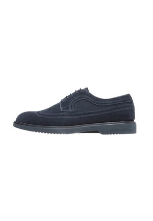 Navy blue suède schoenen met een ronde neus, decoratieve perforaties en een contrasterende zwarte rubberen zool hebben een vetersluitingen ontwerp.