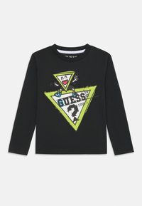 Schwarzes Langarm-T-Shirt mit einem lebendigen grünen und weißen Dreiecksgrafik, das ein Cartoon-Gesicht und Text zeigt. Aus weichem Baumwollstoff gefertigt.