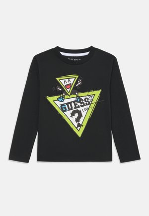 Camiseta de manga larga negra con un gráfico en triángulo vibrante en verde y blanco que presenta una cara de dibujo animado y texto. Fabricada con suave tela de algodón.