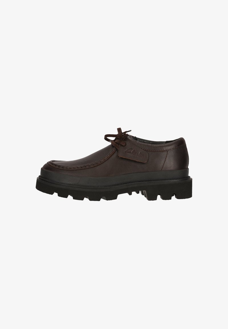 Chaussure décontractée en cuir marron foncé avec lacets, semelle épaisse en caoutchouc noir à relief, étiquette latérale avec logo et détails cousus.