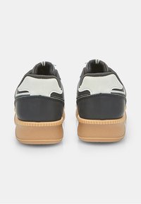 Black and gray athletic shoes with a textured gum sole, featuring padded collars and contrasting white accents on the heel.