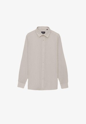 Beżowa koszula na długi rękaw z kołnierzykiem i mankietami, z subtelną teksturą i małym haftowanym logo na lewej piersi.