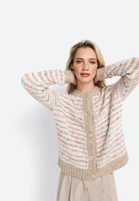 Cardigan texturé présentant un mélange de couleurs pastel, un tricot épais, un ourlet côtelé et de grands boutons, avec un col rond et une coupe décontractée.