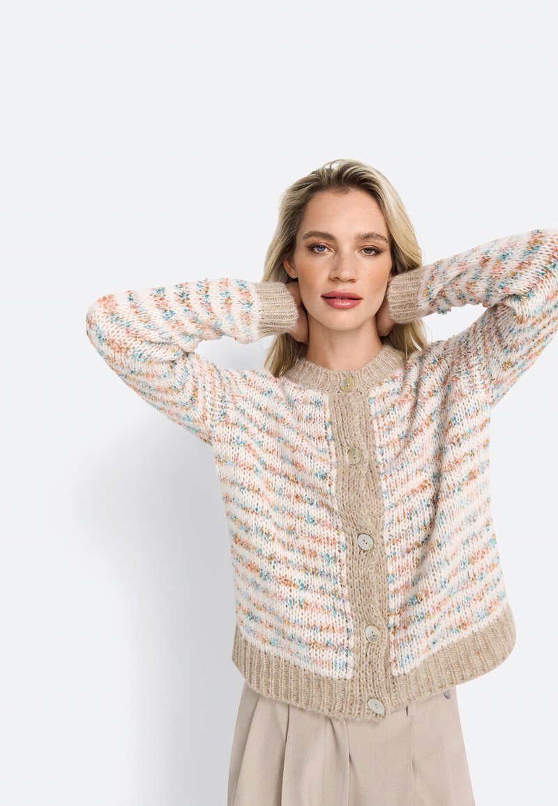 Cardigan texturé présentant un mélange de couleurs pastel, un tricot épais, un ourlet côtelé et de grands boutons, avec un col rond et une coupe décontractée.