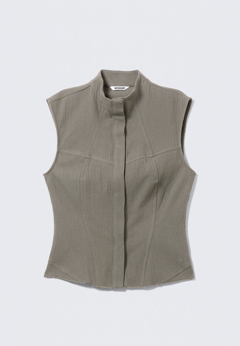 Veste grise sans manches en tissu texturé, dotée d'un col haut et d'une fermeture centrale à boutons, avec des coutures ajustées et une silhouette cintrée.