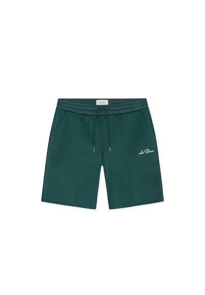 Shorts vert foncé en tissu doux, dotés d'une ceinture élastique avec un cordon de serrage et des poches latérales. Logo brodé sur le devant.