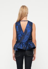 Μπλε τοπ με φλοράλ σχέδιο και πεπλούμ, με V-λαιμόκοψη στην πλάτη, χωρίς μανίκια και κούμπωμα με κουμπιά στον λαιμό. Λιτή υφή.