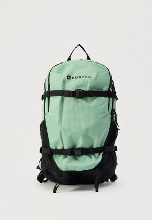 Zaino Burton in verde menta chiaro e nero, con spallacci regolabili, chiusure con fibbia e tessuto resistente con forma strutturata.