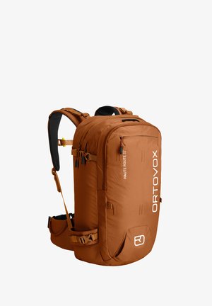 Brown backpack with multiple compartments, padded shoulder straps, and a durable fabric. Features branding "ORTOVOX" and "HAUTE ROUTE 32."
