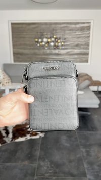 Γκρι υφασμάτινη θήκη διπλού φερμουάρ με λογότυπο VALENTINO. Διαθέτει πάνω τσέπη και μεγαλύτερο κάτω χώρο με γυαλιστερες λεπτομέρειες.