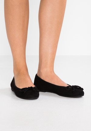 Czarne zamszowe baleriny z okrągłym noskiem i dekoracyjnym węzłem z przodu. Płaska podeszwa i gładka tekstura.