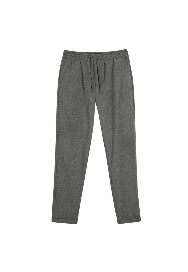 Pantalones grises ligeros con cintura elástica y cordón, piernas ajustadas, textura suave y sin patrones visibles ni elementos metálicos.
