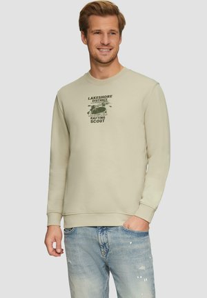 Sweatshirt beige clair avec un col rond et des poignets côtelés, arborant un motif graphique vert foncé centré sur la poitrine.