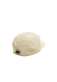 Gorra beige con una corona redondeada, visera corta y tela texturizada. Presenta un regulador de toggle negro en la parte posterior.