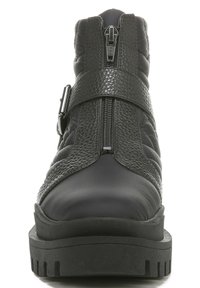 Bottine en cuir noir avec fermeture éclair à l'avant, sangle texturée avec boucle, côtés rembourrés, et semelle épaisse en caoutchouc.