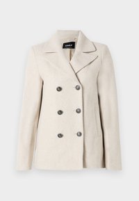 Manteau beige croisé en tissu doux et texturé, avec un revers cranté et six boutons noirs décoratifs, ainsi que deux poches latérales.