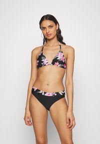 Μπικίνι σετ με τριγωνικό τοπ με ροζ και λευκά λουλουδάτα σχέδια σε μαύρο φόντο, συνδυασμένο με εντελώς μαύρα σλιπ με λουλουδάτες λεπτομέρειες.