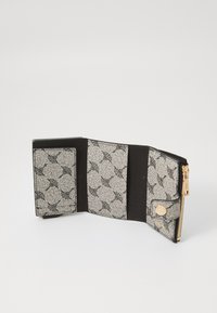 Black and white wallet featuring a textured exterior with floral patterns, gold hardware, and multiple card slots inside. Zip closure.