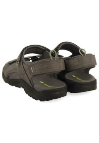 Sandalias exteriores grises con correas texturizadas, cierres de Velcro ajustables, plantilla acolchada y suela exterior de goma negra duradera. Se aprecian acentos verdes.