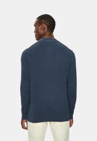 Maglione a coste blu navy con scollatura rotonda, maniche lunghe e vestibilità comoda. Caratterizzato da un tessuto testurizzato e un orlo allungato.