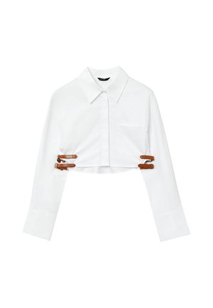 Camicia bianca cropped con colletto a punta, maniche lunghe, taschino frontale e dettagli in pelle marrone con fibbie per una vestibilità regolabile.