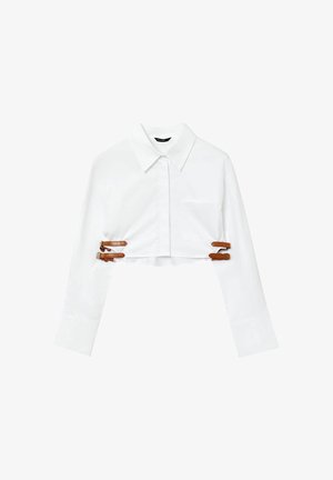 Chemise blanche coupée avec un col pointu, des manches longues, une poche avant et des accents en cuir marron avec boucle pour un ajustement réglable.