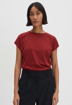 Red short-sleeve T-shirt in light, soft fabric with a relaxed fit and round neckline, paired with black tailored trousers.