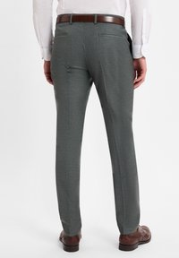 Gray tailored trousers in a fine-textured fabric, featuring a slim fit, and a flat front design. Completed with a brown leather belt and shoes.