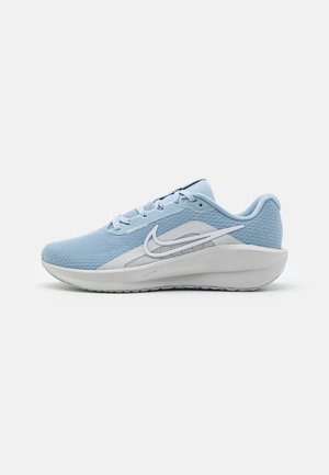 Jasnoniebieski but sportowy z białym logo Nike, siateczkową cholewką, amortyzowaną podeszwą i sznurowaniem, widoczny z boku na białym tle.