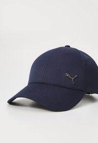 Navy baseball cap made of fabric, featuring a curved visor and a metallic silver Puma logo on the front. Smooth texture with stitched detailing.