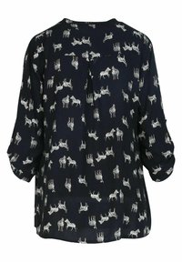 Blouse marine avec un motif zèbre blanc. Tissu doux avec des manches longues et une coupe ample, conçue avec un pli arrière subtil pour plus de détails.
