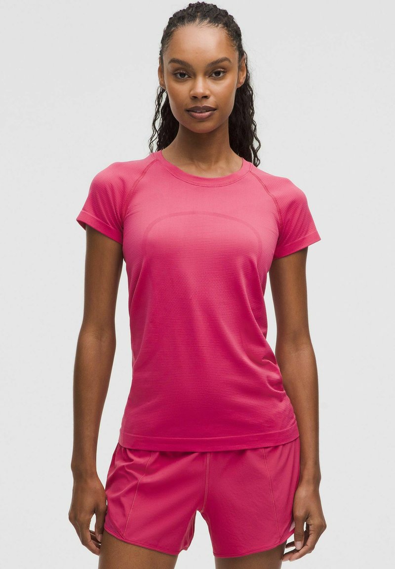 Felroze sport T-shirt met korte mouwen, ronde halslijn en textuurstof, gecombineerd met bijpassende shorts voor sportieve kleding.