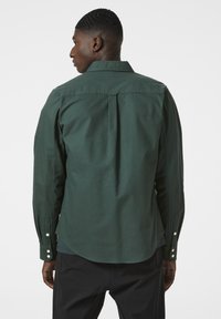 Groene katoenen shirt met lange mouwen, een puntige kraag en knoopmanchetten, met een plooi detail aan de achterkant en een gebogen zoom.