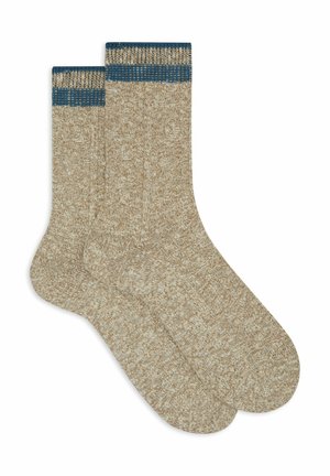 Calze a maglia beige con un motivo testurizzato e un polsino a coste blu scuro. Il tessuto appare morbido e ha una finitura leggermente pelosa.