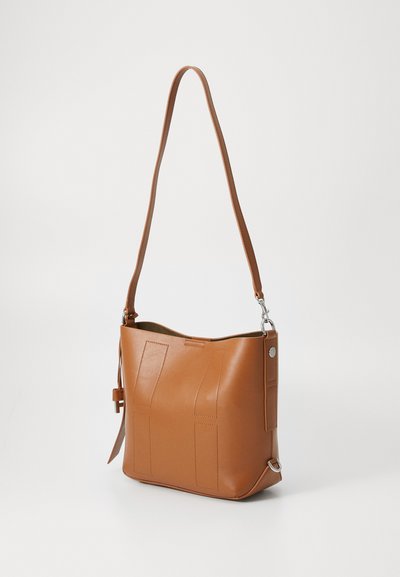 Brown leather shoulder bag with a structured shape, featuring stitched panels, a long strap, and a side hardware accent. Smooth texture.