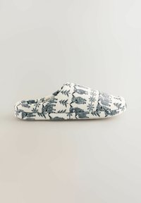 Wit met een donkerblauw natuurpatroon dat beren en bomen afbeeldt, gevoerde pantoffels van fleece. Instapmodel met een afgeronde neus.