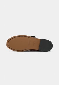 Semelle de chaussure en cuir de teinte marron, dotée d'une finition lisse, d'un bord cousu et d'un talon en caoutchouc noir pour une meilleure adhérence.