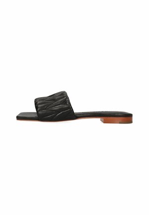 Sandale en cuir noir à glissière avec un dessus texturé et matelassé. Semelle plate avec une finition lisse et un petit accent en bois au talon.