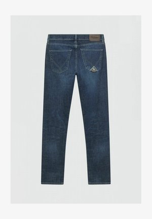 Jeans in denim blu scuro mostrati da dietro con due tasche cucite, un'etichetta del marchio in pelle sulla cintura e una piccola etichetta sulla tasca destra.