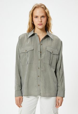Gestreepte button-up shirt in groen en crème, met twee borstzakken, een relaxte pasvorm en een puntige kraag. Gemaakt van lichtgewicht stof.