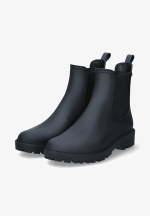 Zwarte rubberen Chelsea boots met elastische zijpanelen, ronde neus, gestructureerde buitenzool en trekflappen voor gemakkelijk aan- en uittrekken. Glad matte afwerking.