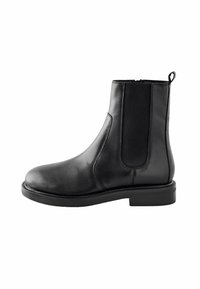 Musta nahkainen nilkkaboots, jossa on elastinen sivupaneeli, vetotappi kantapäässä, matala pinottu korko ja pyöreä varvas.