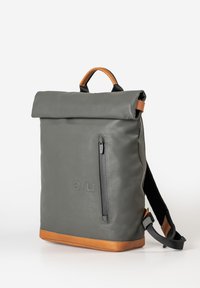 Gray roll-top backpack made of durable material, featuring a front zip pocket, brown leather accents, and adjustable straps.