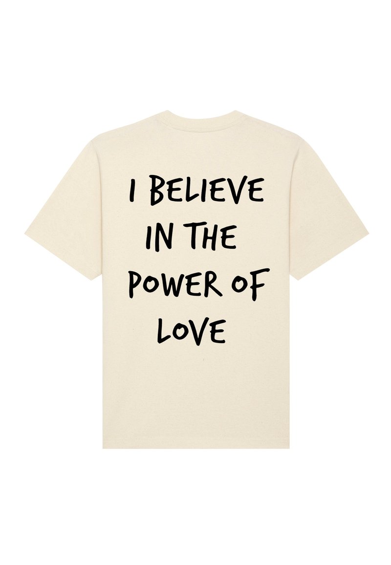 Crème-kleurig T-shirt met vetgedrukte, zwarte tekst op de achterkant die luidt: "IK Geloof IN DE KRAACHT VAN LIEFDE." Zachte katoenen stof, korte mouwen.