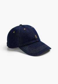 Căciulă din denim albastru închis cu o visieră curbată, cusături galbene și un mic logo cu skull pe față. Curea ajustabilă în partea din spate.